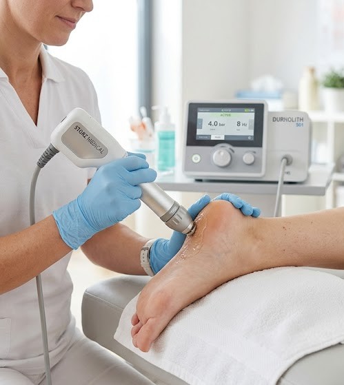 Physiotherapist applying shockwave therapy to a patient's heel
